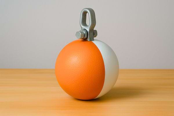 Une boule moitié orange moitié blanche est équipée d’un crochet métallique solide.