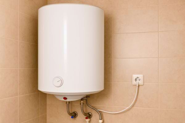 Un chauffe-eau blanc est branché à une prise murale, prêt à être utilisé mais toujours énergivore.