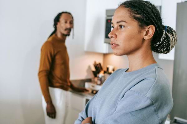 Une femme contrariée tourne le dos à un homme dans une cuisine.