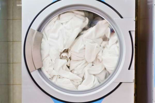 Draps blancs dans machine à laver.