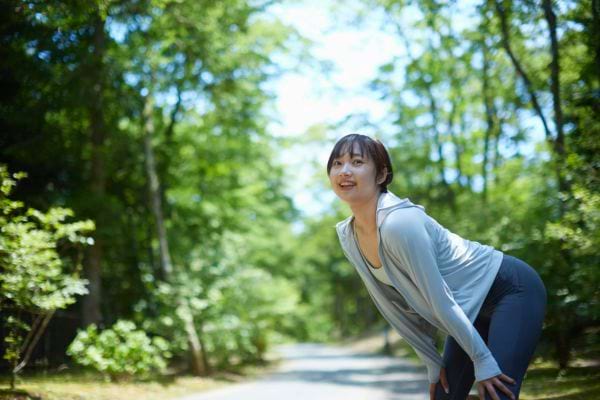 Une femme sportive fatiguée se repose après avoir couru en extérieur.