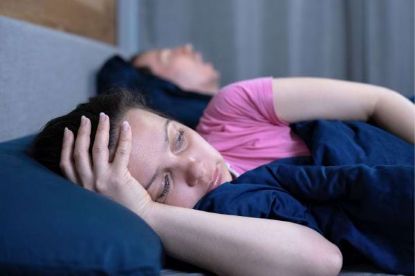 Femme insomniaque au lit.