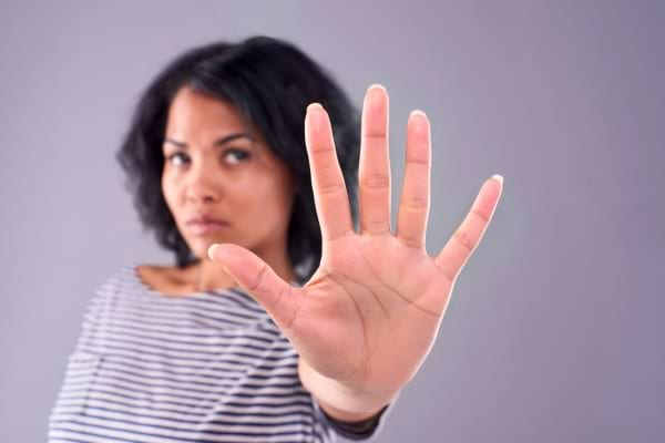 Une femme tend les cinq doigts de la main vers l’avant.