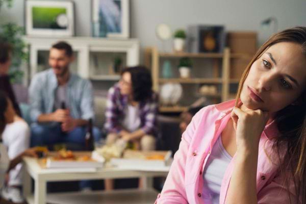 Une femme pensive isolée lors d’une réunion amicale.