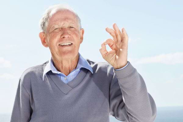 Vieil homme levant la main en signe de "ok".