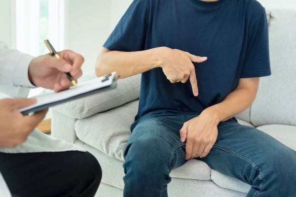 Un homme consulte un médecin en évoquant une gêne intime.