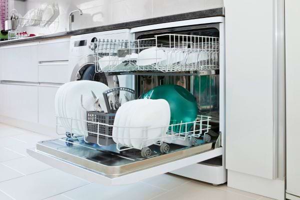 Un lave-vaisselle rempli d’assiettes, verres et couverts propres.
