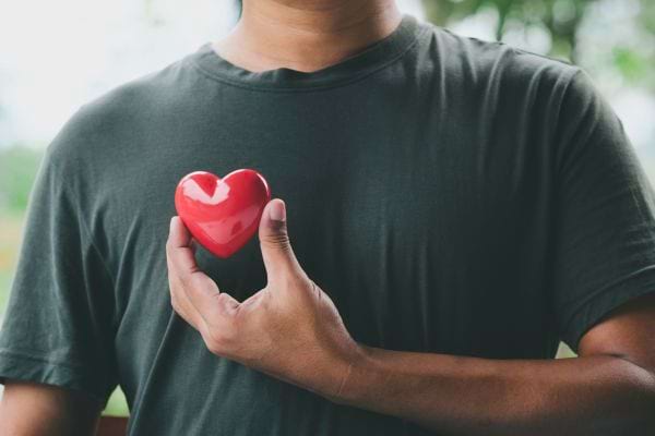 Personne tenant un cœur rouge symbole de la santé.