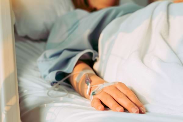 La main d’un patient allongé à l’hôpital avec une perfusion.