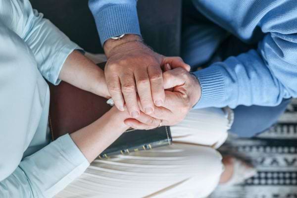 Deux personnes se tiennent les mains en signe de soutien.