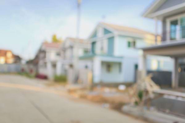 Des maisons modernes apparaissent floues au bord d’une rue.