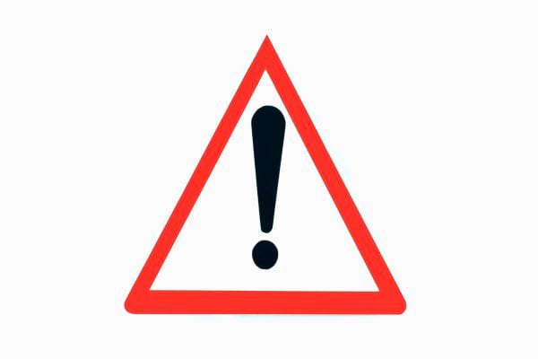 Un panneau triangulaire rouge avec un point d’exclamation signale un avertissement.