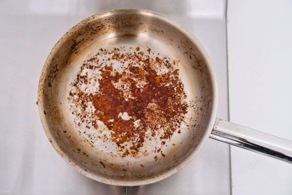 Poêle tachée de résidus bruns après cuisson.