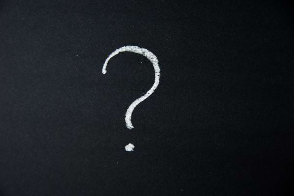 Un point d’interrogation blanc tracé sur un fond noir.
