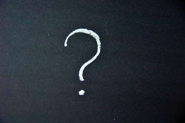 Un point d’interrogation blanc est dessiné sur un fond noir.
