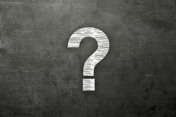 Point d’interrogation blanc dessiné sur un tableau noir.