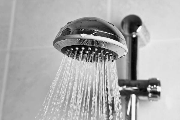 Pommeau de douche mural laissant couler un jet d’eau.