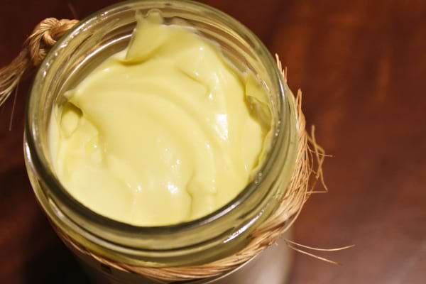 Un pot en verre contient de la mayonnaise maison à la texture onctueuse.