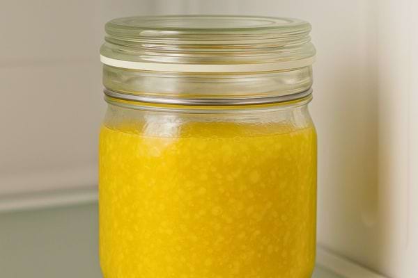 Un pot en verre rempli d’une préparation jaune épaisse.