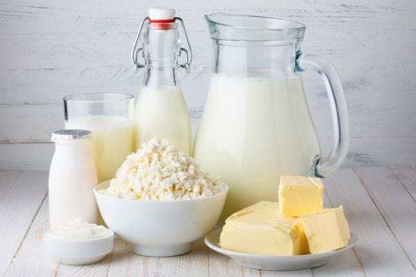 Plusieurs produits laitiers sont disposés : lait, beurre, fromage blanc et yaourt.