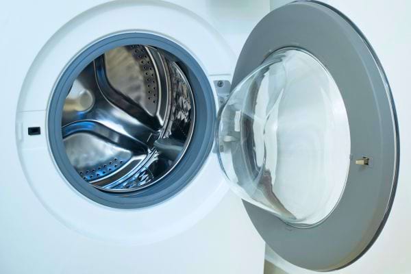 Un tambour de machine à laver ouvert et vide, prêt pour un nouveau cycle.
