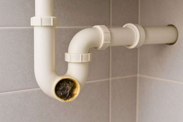 Un tuyau en plastique blanc de cuisine révèle un bouchon visible.