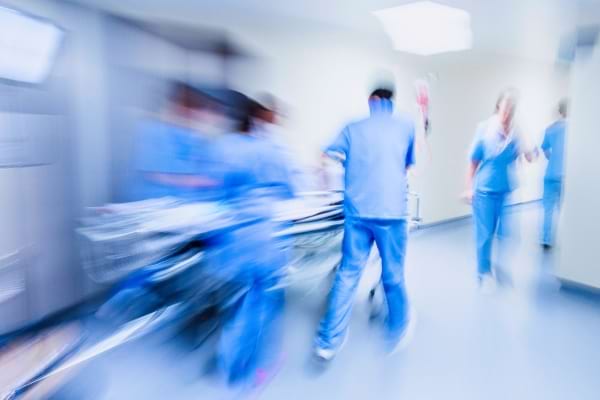 Des soignants s’activent rapidement dans un couloir d’hôpital.