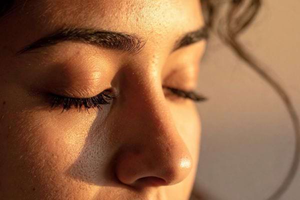 Gros plan d’un visage féminin avec les yeux fermés.