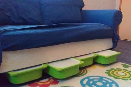 Des conteneurs Trofast sous le canapé utilisé pour ranger les jouets.