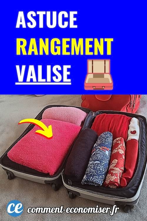 Valise ouverte contenant des vêtements bien pliés et roulés avec flèche jaune sur une serviette rose.
