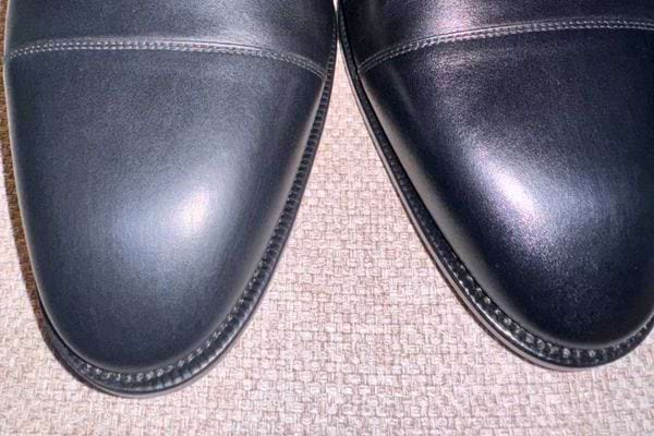 Deux chaussures en cuir noir brillantes côte à côte.