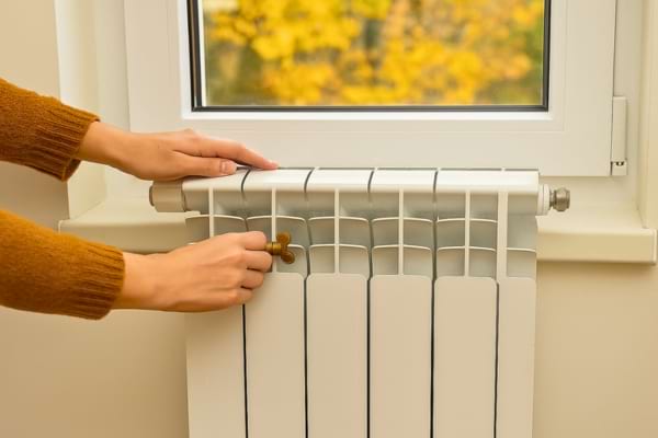 une personne purgeant un radiateur avec une clé