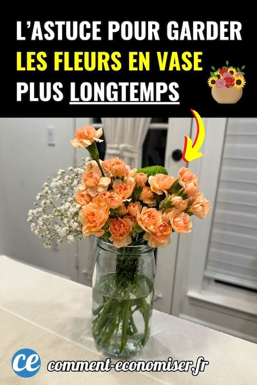 Bouquet de fleurs orange dans un bocal transparent sur table blanche.