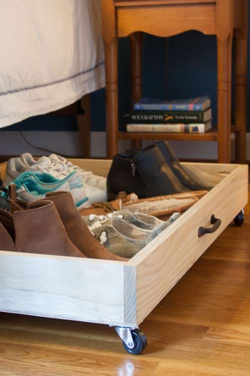 Tiroirs coulissants sous un lit, utilisés pour ranger des objets personnels et accessoires du quotidien.