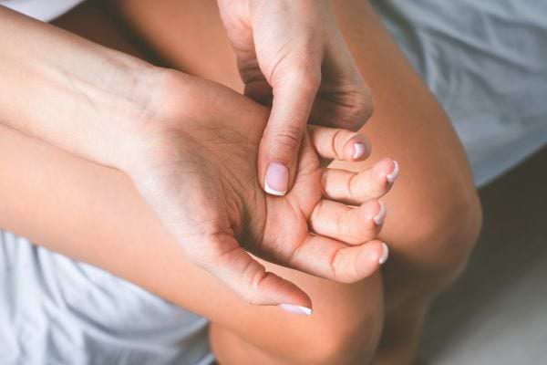 Une main presse l’autre paume, comme pour soulager une douleur.