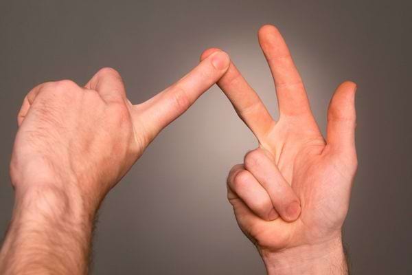 Deux mains forment la lettre W en croisant les doigts dans les airs.