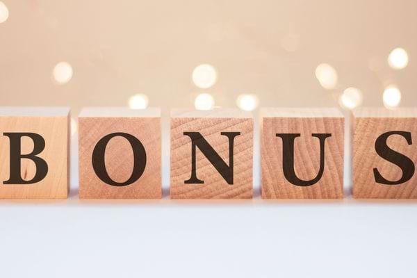 Le mot BONUS formé avec des cubes en bois sur fond lumineux.