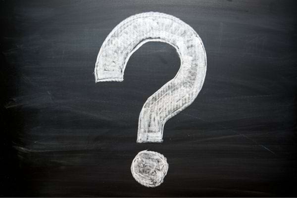 Grand point d’interrogation dessiné à la craie blanche sur un tableau noir.