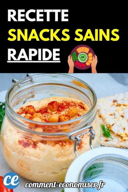 Pot de houmous crémeux décoré avec pois chiches et paprika.