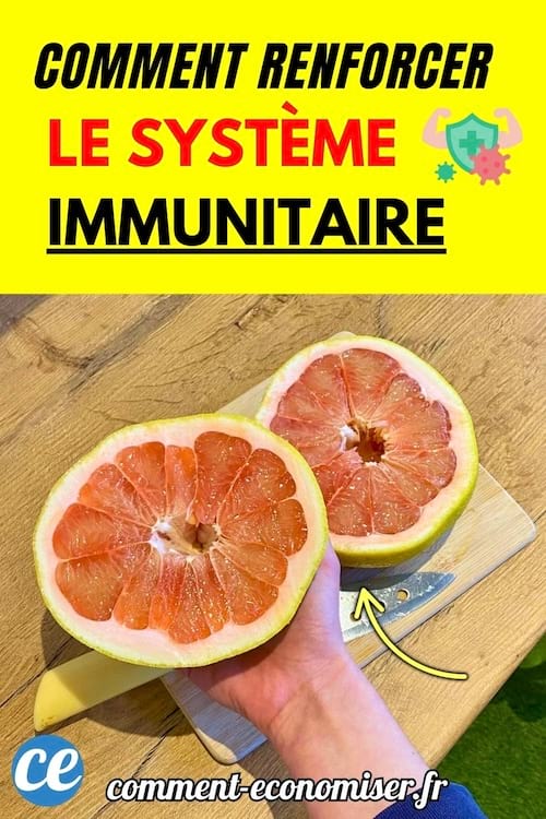 Demi-pamplemousse rose tenu à la main sur planche.