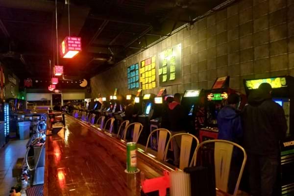 Une salle d’arcade animée avec des machines de jeux alignées.