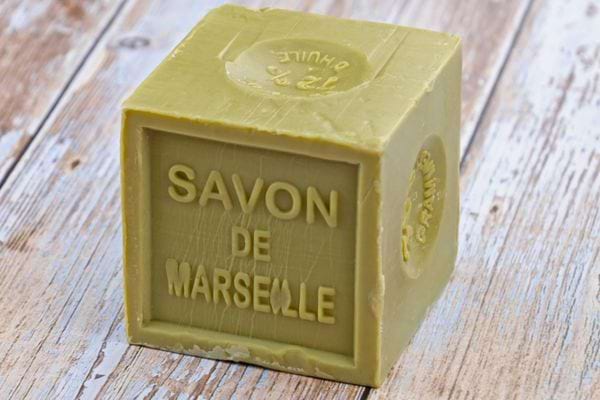 Cube de savon de Marseille vert clair marqué “Savon de Marseille”.