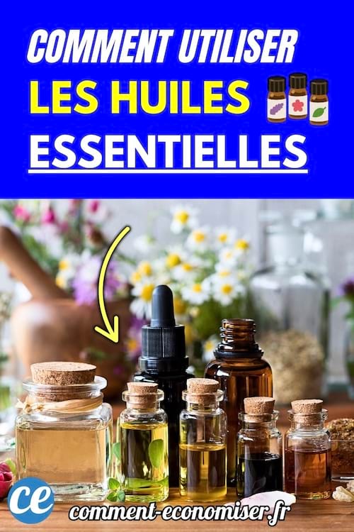 Flacons d’huiles essentielles posés sur une table en bois avec fleurs en arrière-plan.