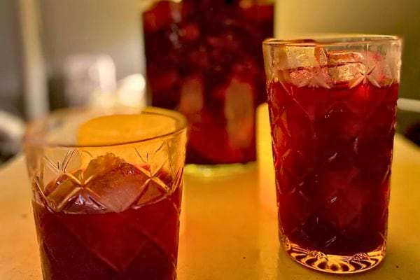 Deux verres remplis d’une boisson rouge servie fraîche, probablement du jus de bissap ou une infusion fruitée.