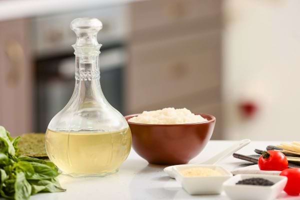 Une bouteille de vinaigre à côté d’un bol de riz.