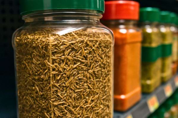 Un bocal rempli de thym séché se trouve sur une étagère d’épicerie.