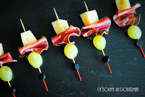 des mini brochettes avec du raisin, du fromage et du jambon