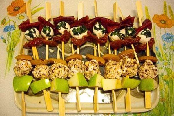 petites brochettes avec de la viande grison, des fruits, de la mozzarella, de la feta