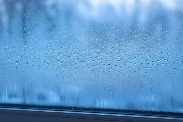 Vitres avec gouttes de condensation en gros plan, lumière naturelle hivernale