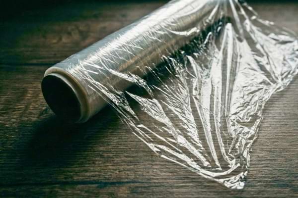 Un rouleau de film alimentaire toxique sur une table